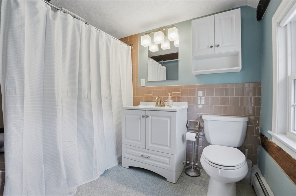 61 Main Street Hanover, MA 02339 - Photo 22 of 38 a bathroom with a toilet a sink and a mirror