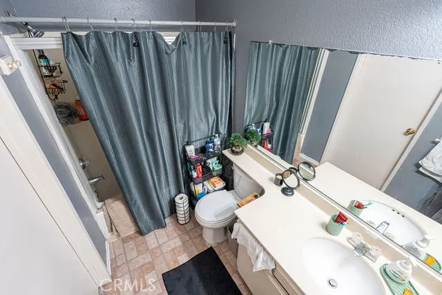 a bathroom with a sink a toilet and shower curtain