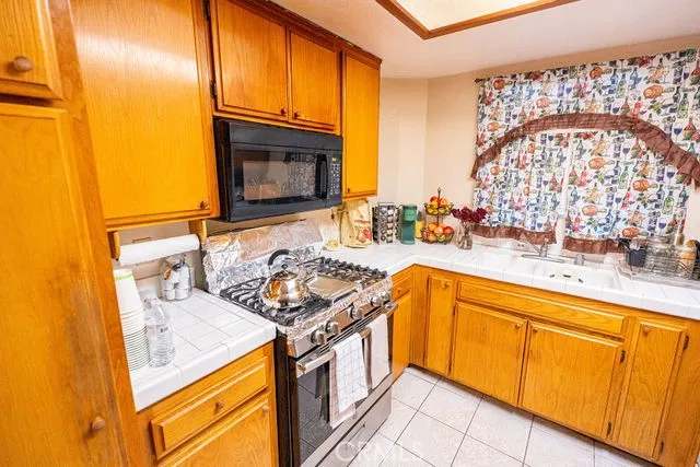 a kitchen with stainless steel appliances granite countertop a sink stove and cabinets