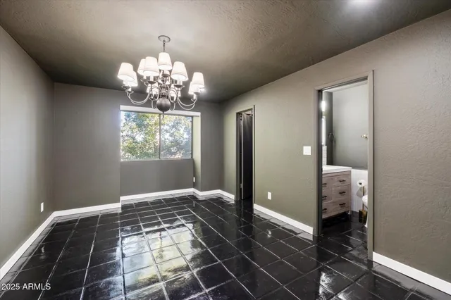 a view of a hallway with wooden floor and a chandelier