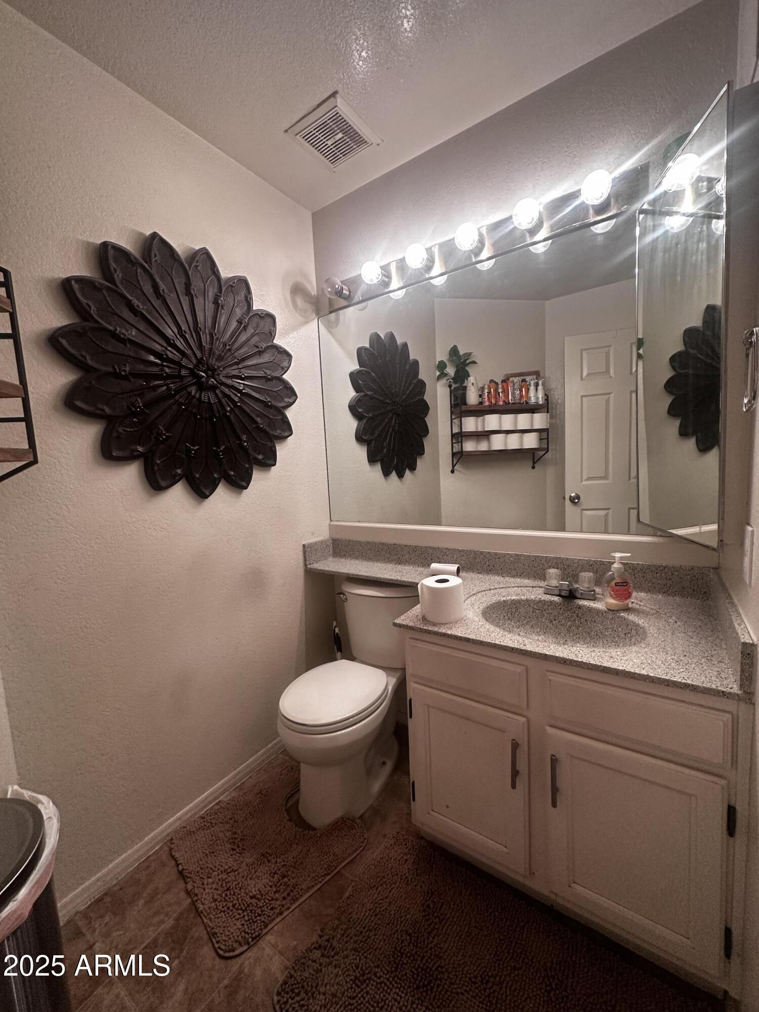 1331 West Baseline Road, Unit 219 Mesa, AZ 85202 - Photo 5 of 17 a bathroom with a toilet sink and mirror