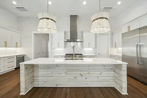 a kitchen with cabinets wooden floor and a chandelier