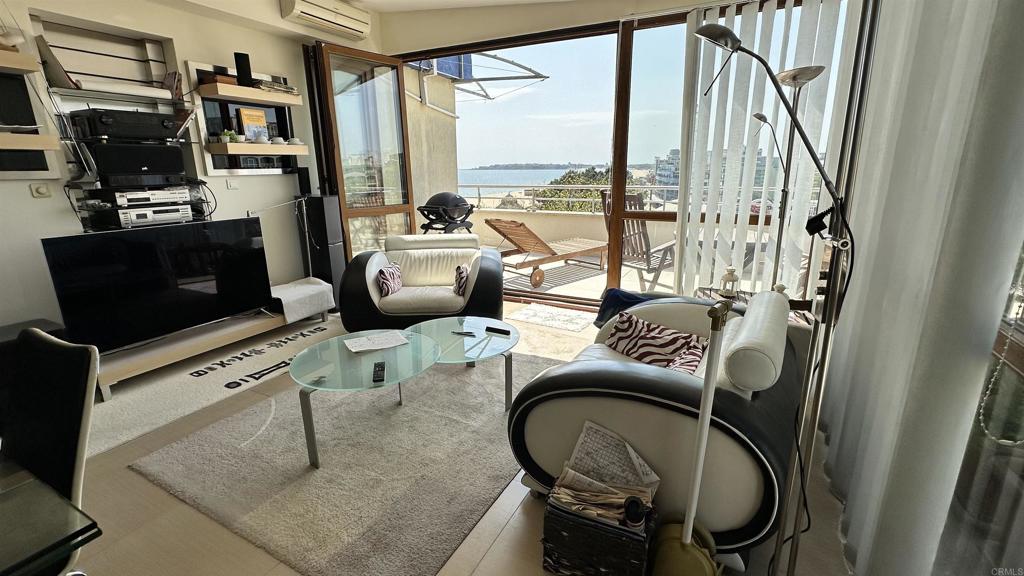 2 Flowers, Unit 51 Absecon, OS 08240 - Photo 7 of 37 a living room with furniture a flat screen tv and a floor to ceiling window