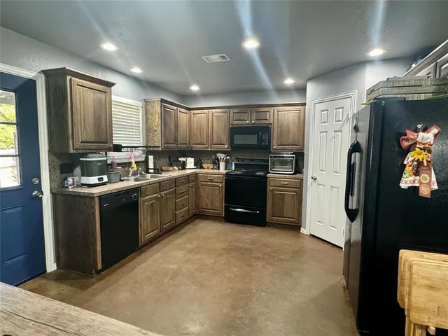 a kitchen with stainless steel appliances granite countertop a refrigerator and a stove top oven