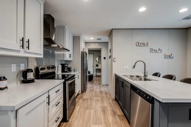 a kitchen with stainless steel appliances granite countertop a sink a stove and cabinets
