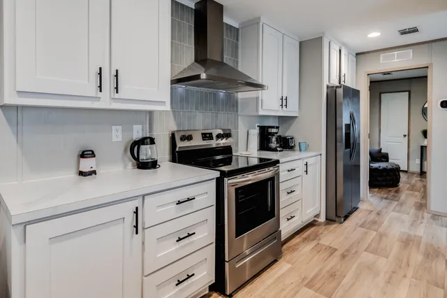a kitchen with stainless steel appliances granite countertop a sink stove and refrigerator