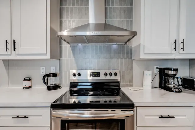a stove top oven sitting inside of a kitchen