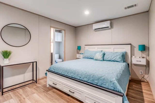 a bedroom with a bed and a potted plant on dresser