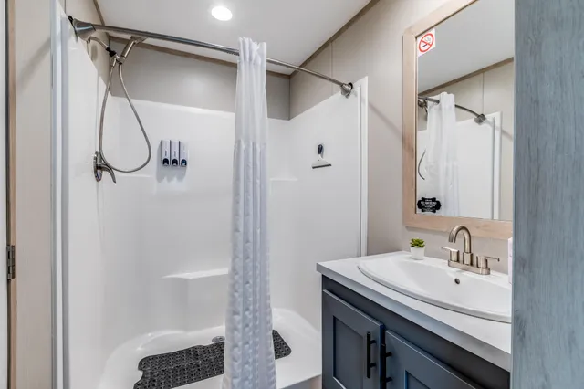 a bathroom with a sink a vanity and shower
