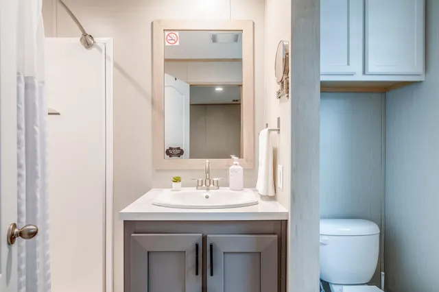 a bathroom with a sink a toilet and shower