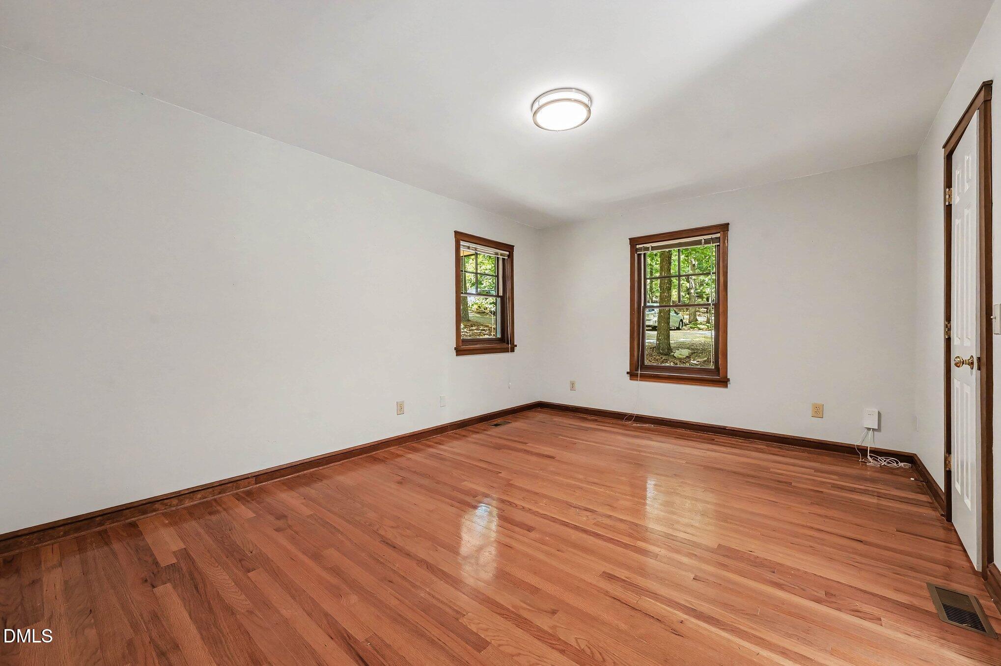 200 Spring Valley Road Carrboro, NC 27510 - Photo 17 of 38 an empty room with wooden floor and windows