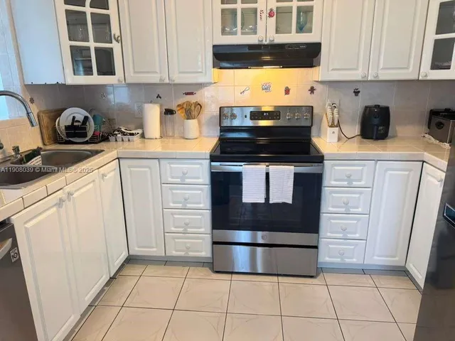 a kitchen with cabinets appliances and a sink