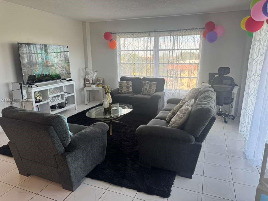 4164 Inverrary Drive, Unit 601 Lauderhill, FL 33319 - Photo 8 of 23 a living room with furniture and a flat screen tv