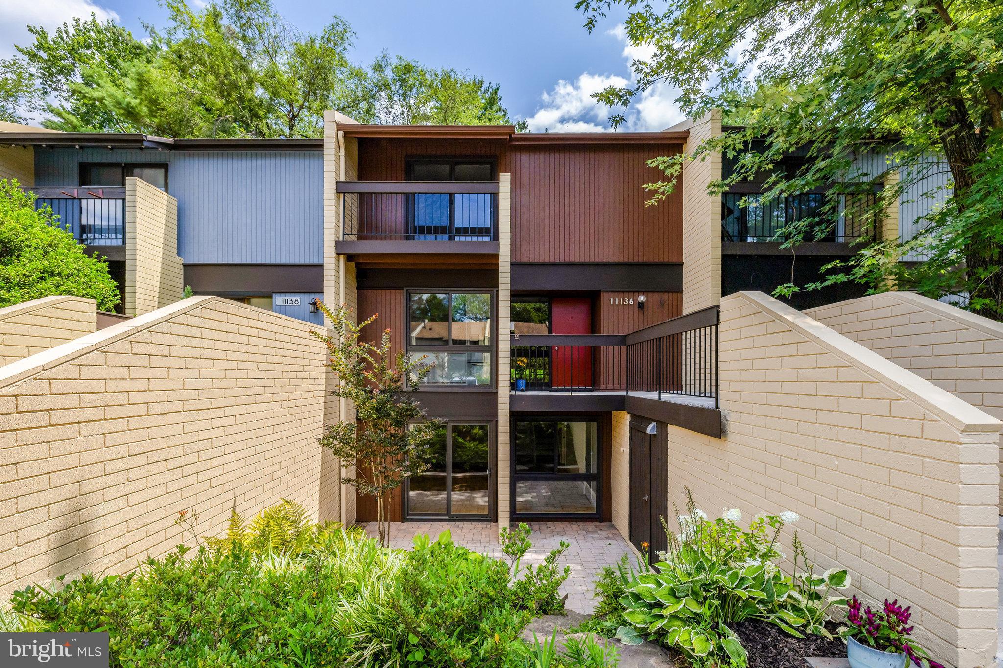 11136 Saffold Way Reston, VA 20190 - Photo 2 of 49 a front view of a house with a yard and potted plants