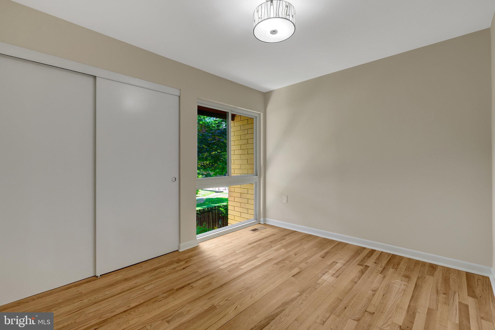 11136 Saffold Way Reston, VA 20190 - Photo 21 of 49 an empty room with wooden floor and windows