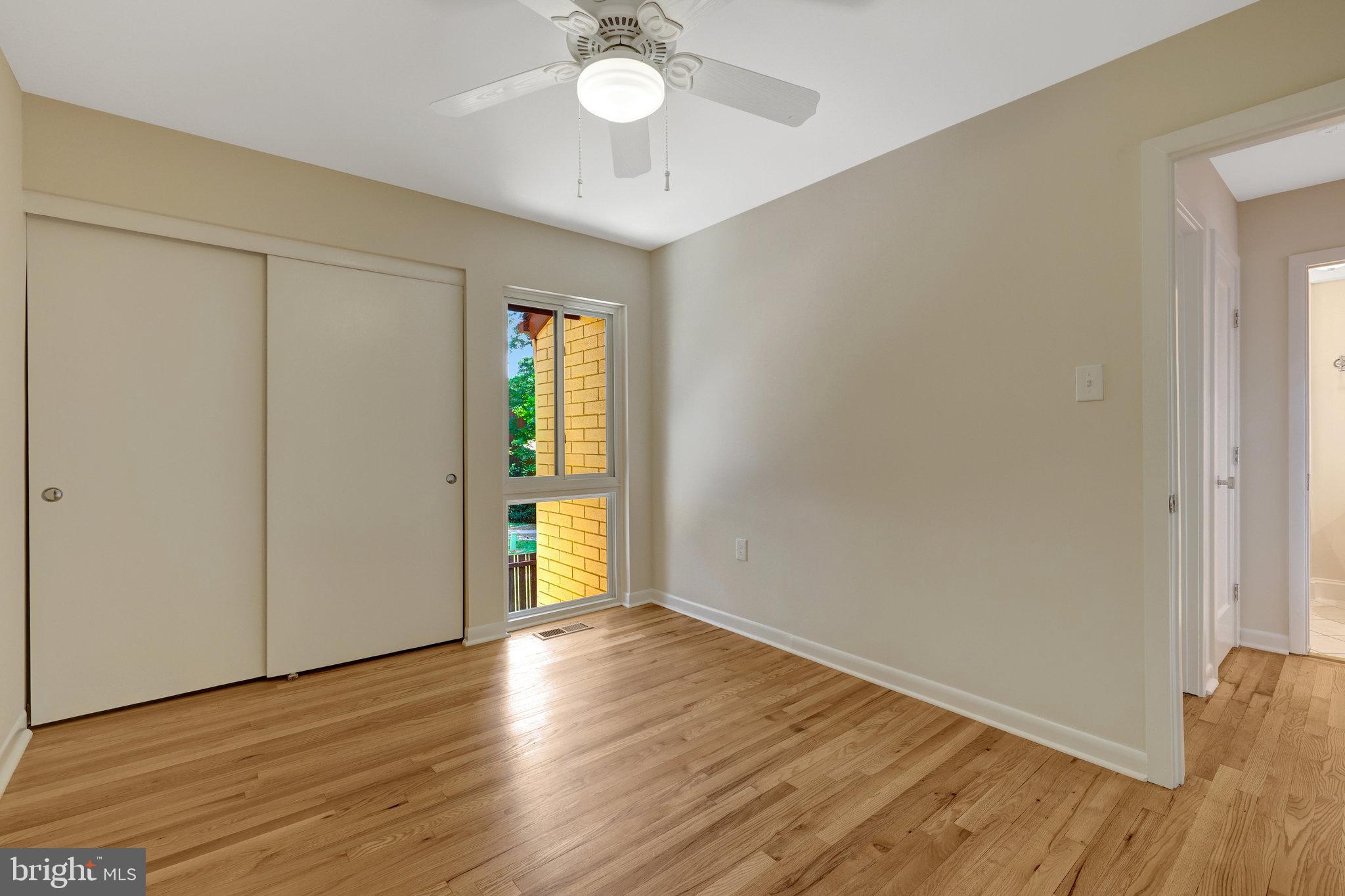 11136 Saffold Way Reston, VA 20190 - Photo 22 of 49 an empty room with wooden floor and windows
