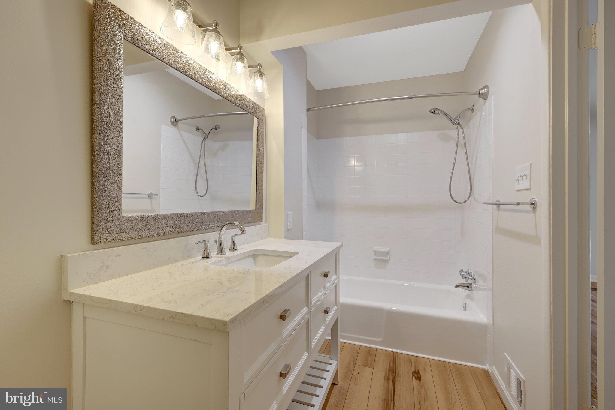 11136 Saffold Way Reston, VA 20190 - Photo 30 of 49 a bathroom with a tub sink and mirror