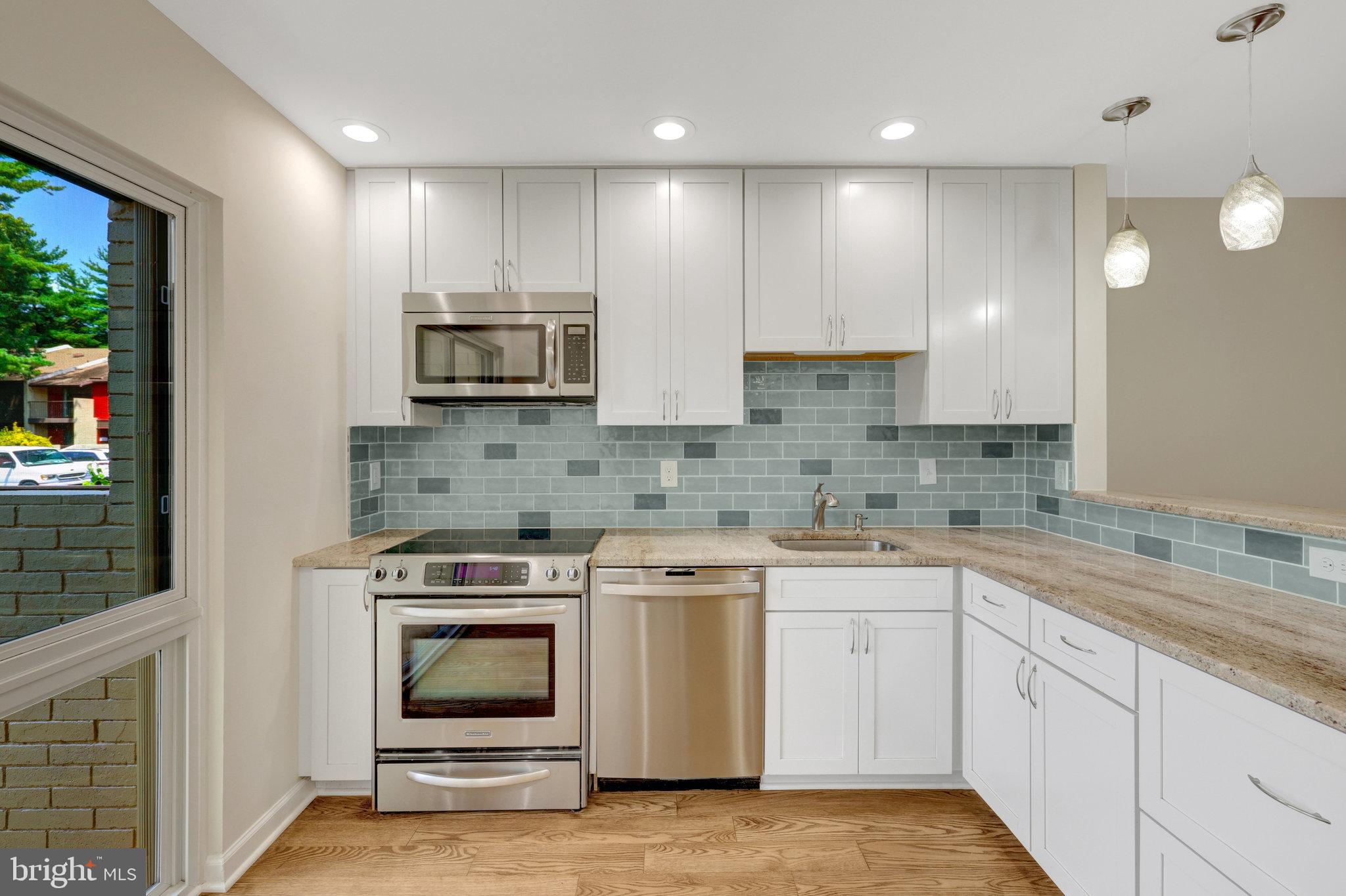 11136 Saffold Way Reston, VA 20190 - Photo 5 of 49 a kitchen with stainless steel appliances granite countertop a stove and a sink