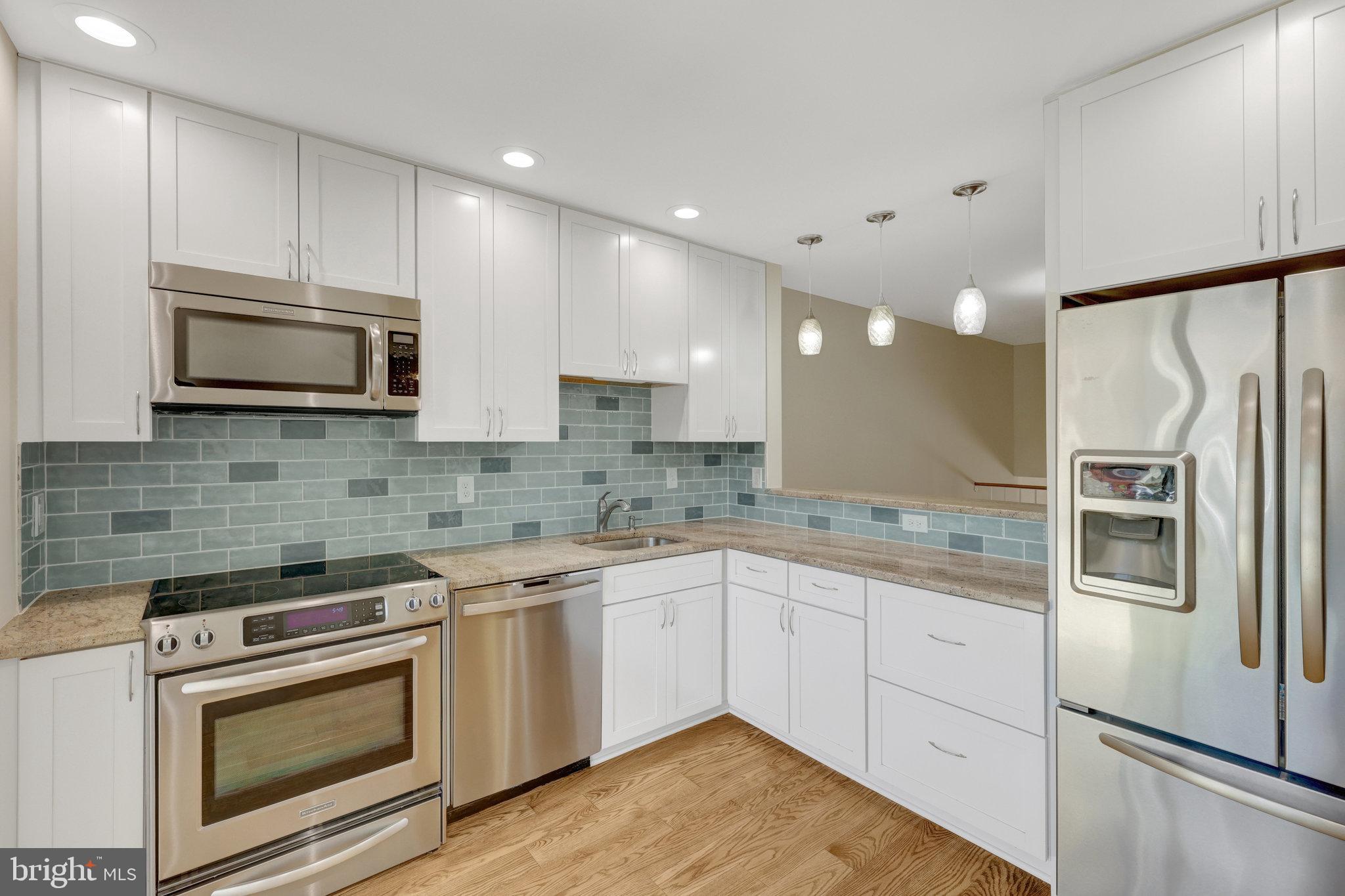 11136 Saffold Way Reston, VA 20190 - Photo 6 of 49 a kitchen with stainless steel appliances granite countertop a refrigerator sink stove microwave and cabinets