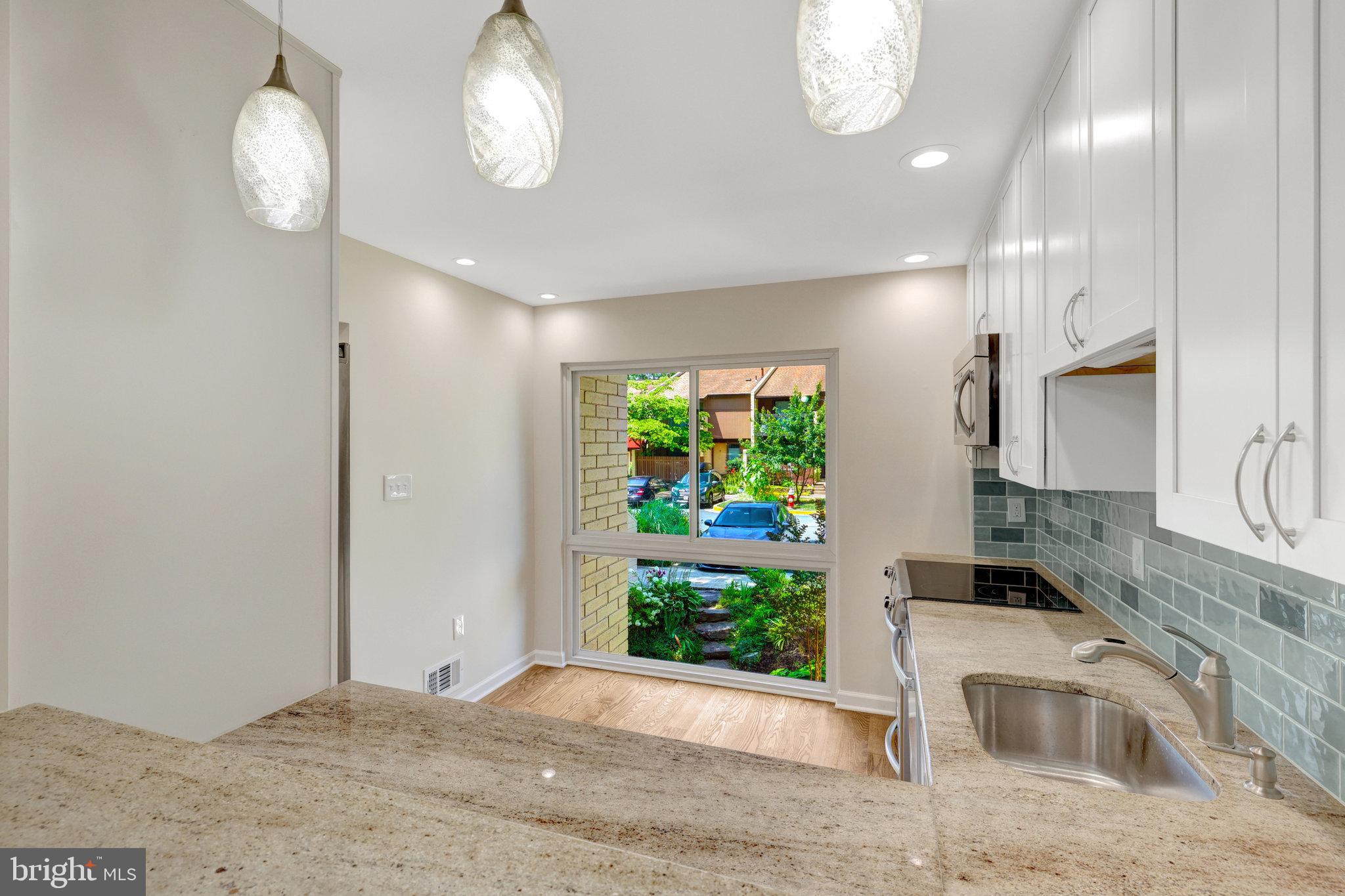 11136 Saffold Way Reston, VA 20190 - Photo 7 of 49 a view of a kitchen with wooden floor and a potted plant