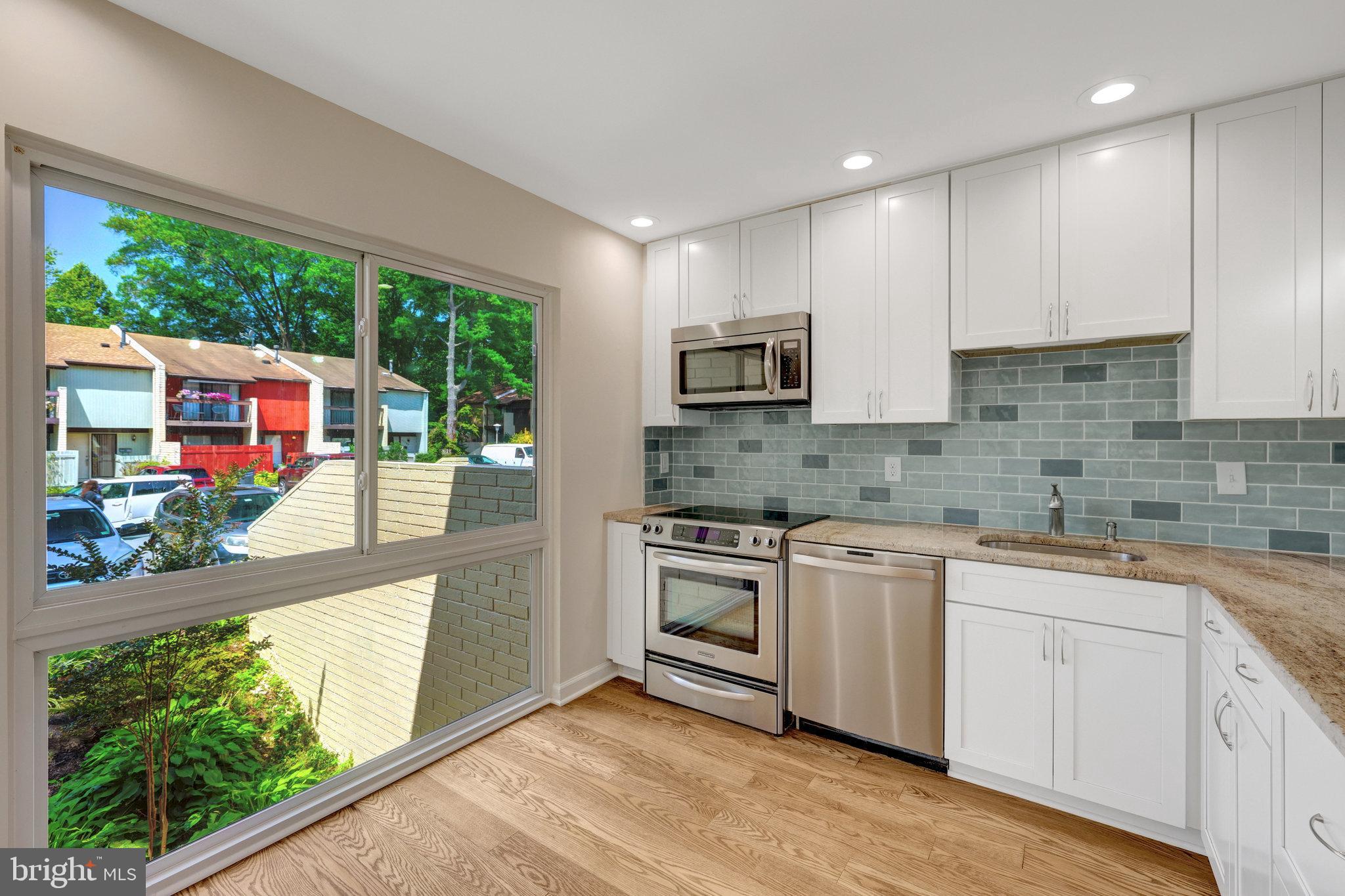 11136 Saffold Way Reston, VA 20190 - Photo 9 of 49 a kitchen with stainless steel appliances granite countertop a stove a sink and a microwave