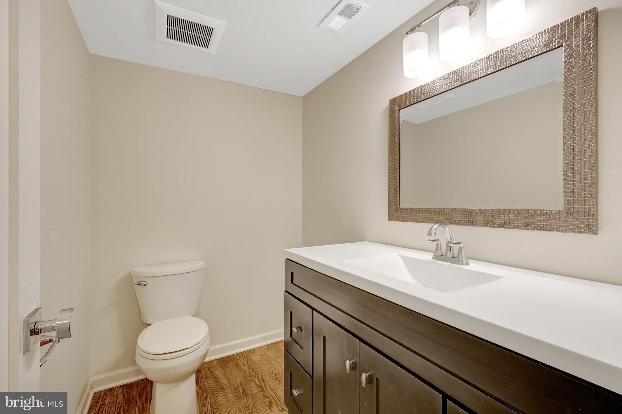 11136 Saffold Way Reston, VA 20190 - Photo 10 of 49 a bathroom with a toilet a sink and mirror