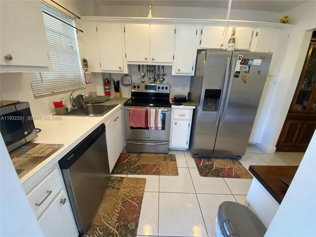 a kitchen with stainless steel appliances a stove a refrigerator and a sink
