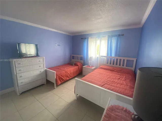 a spacious bedroom with a bed and a flat screen tv