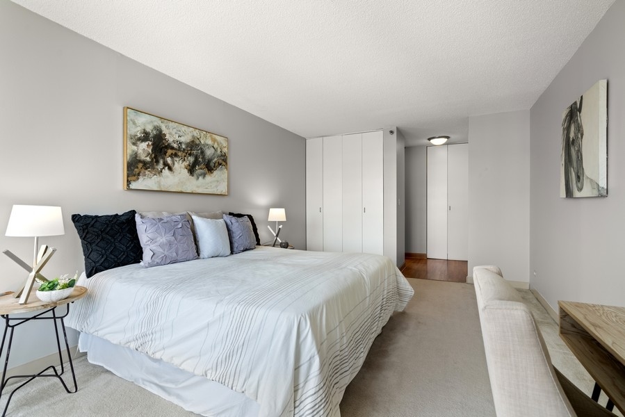 440 North Wabash Avenue, Unit 4706 Chicago, IL 60611 - Photo 13 of 29 a bedroom with bed and paintings on the wall