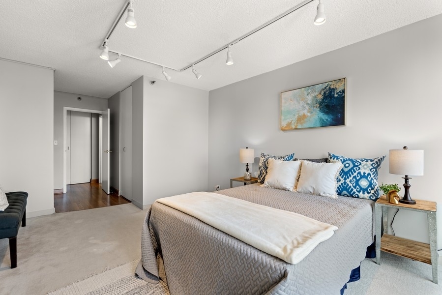 440 North Wabash Avenue, Unit 4706 Chicago, IL 60611 - Photo 16 of 29 a bedroom with a large bed and a chandelier