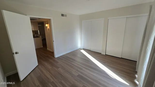 an empty room with wooden floor and closet