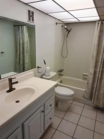 a bathroom with a granite countertop sink a toilet and a shower