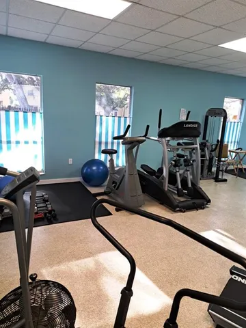 a room with gym equipment and windows