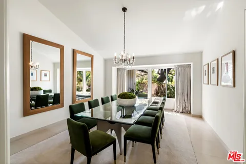 a dining room with furniture large windows and a chandelier