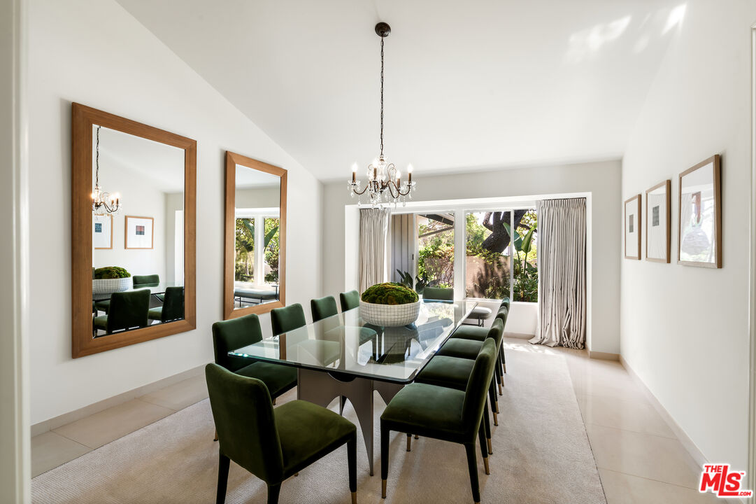 811 North Hillcrest Road Beverly Hills, CA 90210 - Photo 13 of 28 a dining room with furniture large windows and a chandelier
