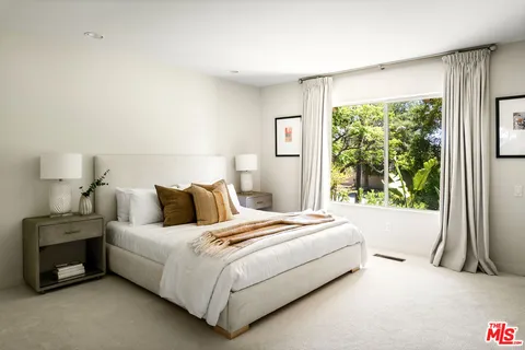 a bedroom with a bed and a large window