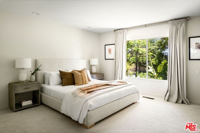 a bedroom with a bed and a large window