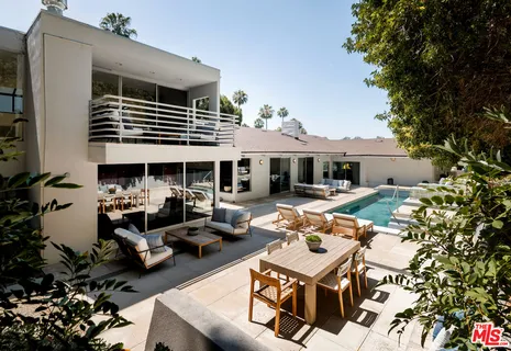 a view of a patio with couches table and chairs and potted plants