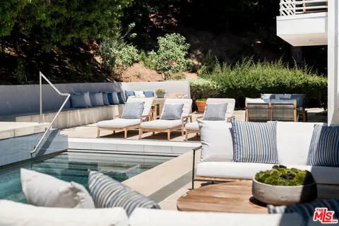a view of a patio with couches table and chairs and potted plants