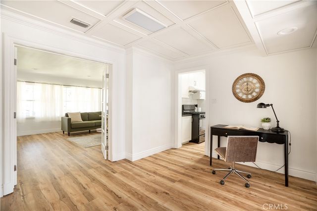 a kitchen with stainless steel appliances granite countertop a sink a stove and white cabinets with wooden floor