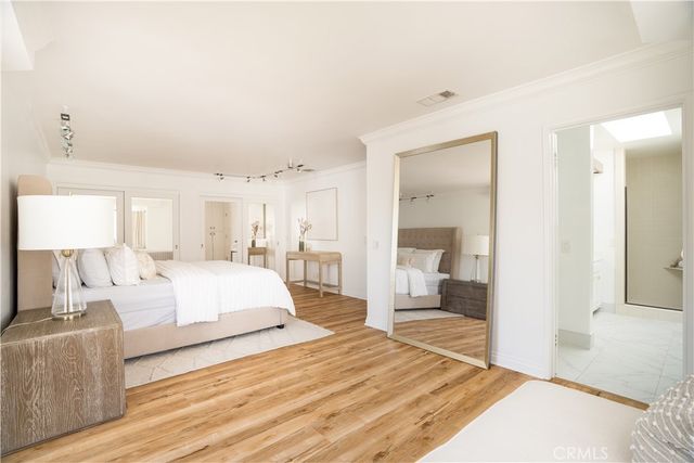 a living room with stainless steel appliances kitchen island granite countertop a sink and a stove with wooden floor