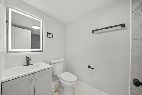 a bathroom with a toilet sink and mirror