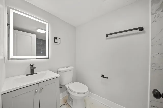 a bathroom with a toilet sink and mirror