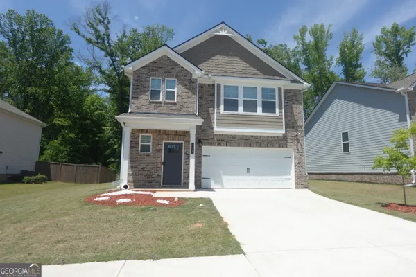 a front view of a house with a yard and garage
