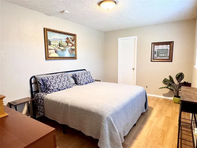 a bedroom with bed and paintings on the wall