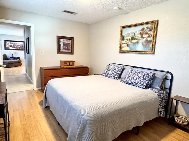a bedroom with bed and wooden floor