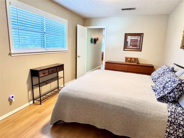 a bedroom with a bed and a dresser next to a window