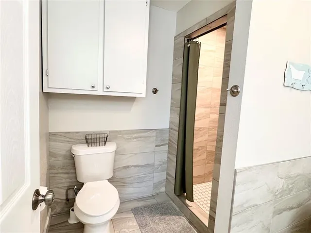 a bathroom with a toilet and a shower
