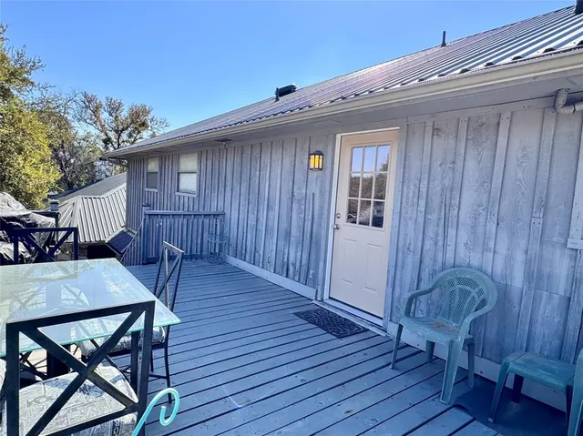 a view of a house with wooden deck and furniture