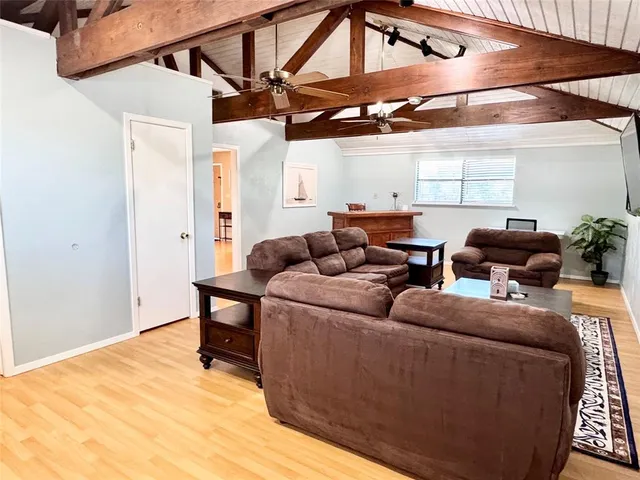 a living room with furniture a ceiling fan and a rug